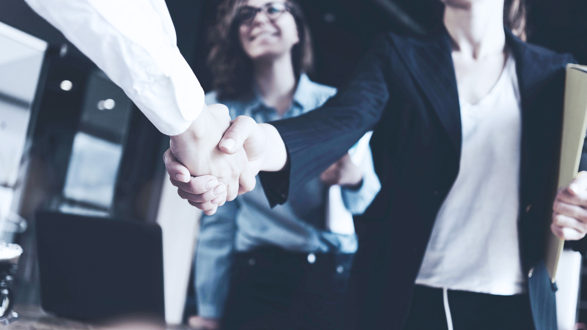 Två personer i affärsmöte som skakar hand