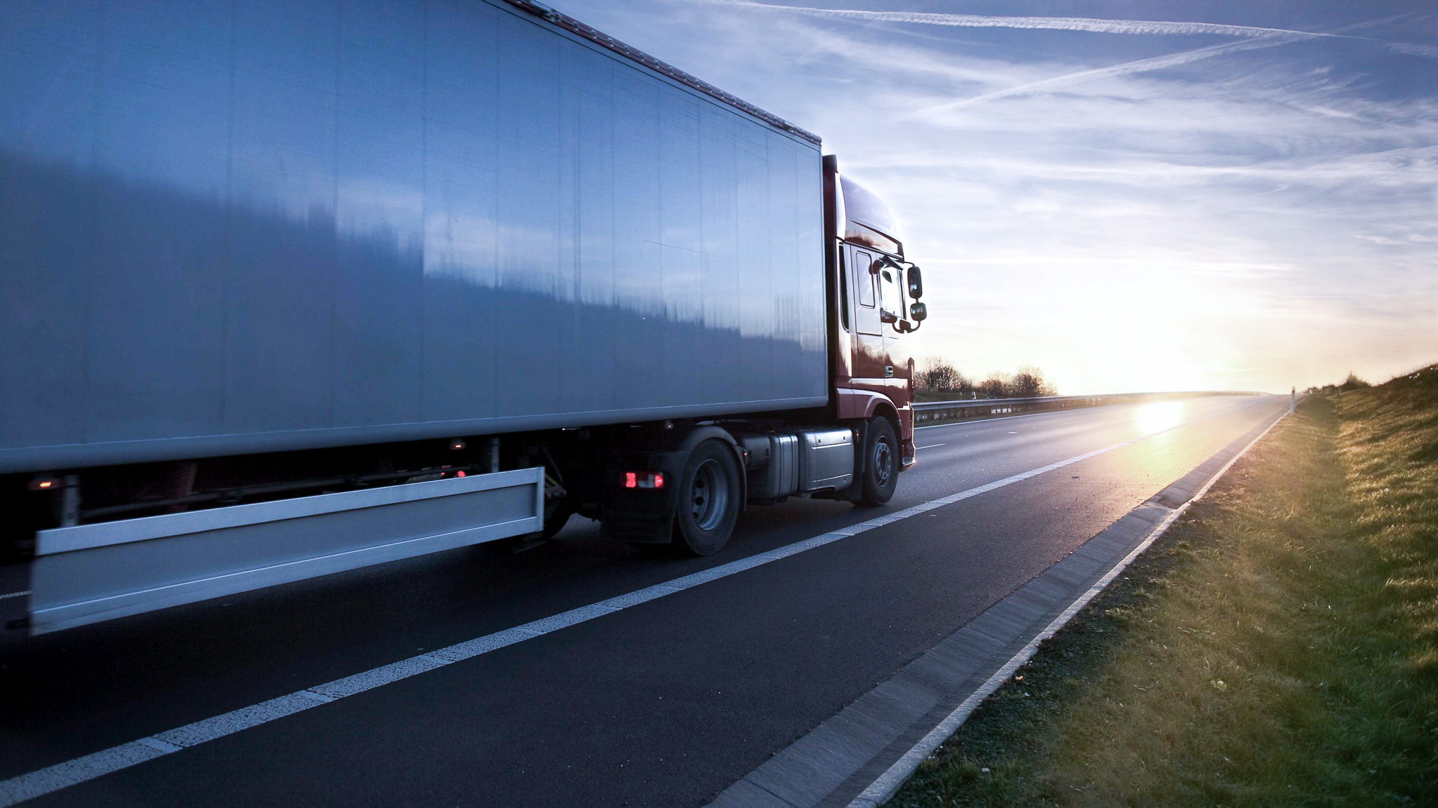 Lastbil på motorväg i solnedgång