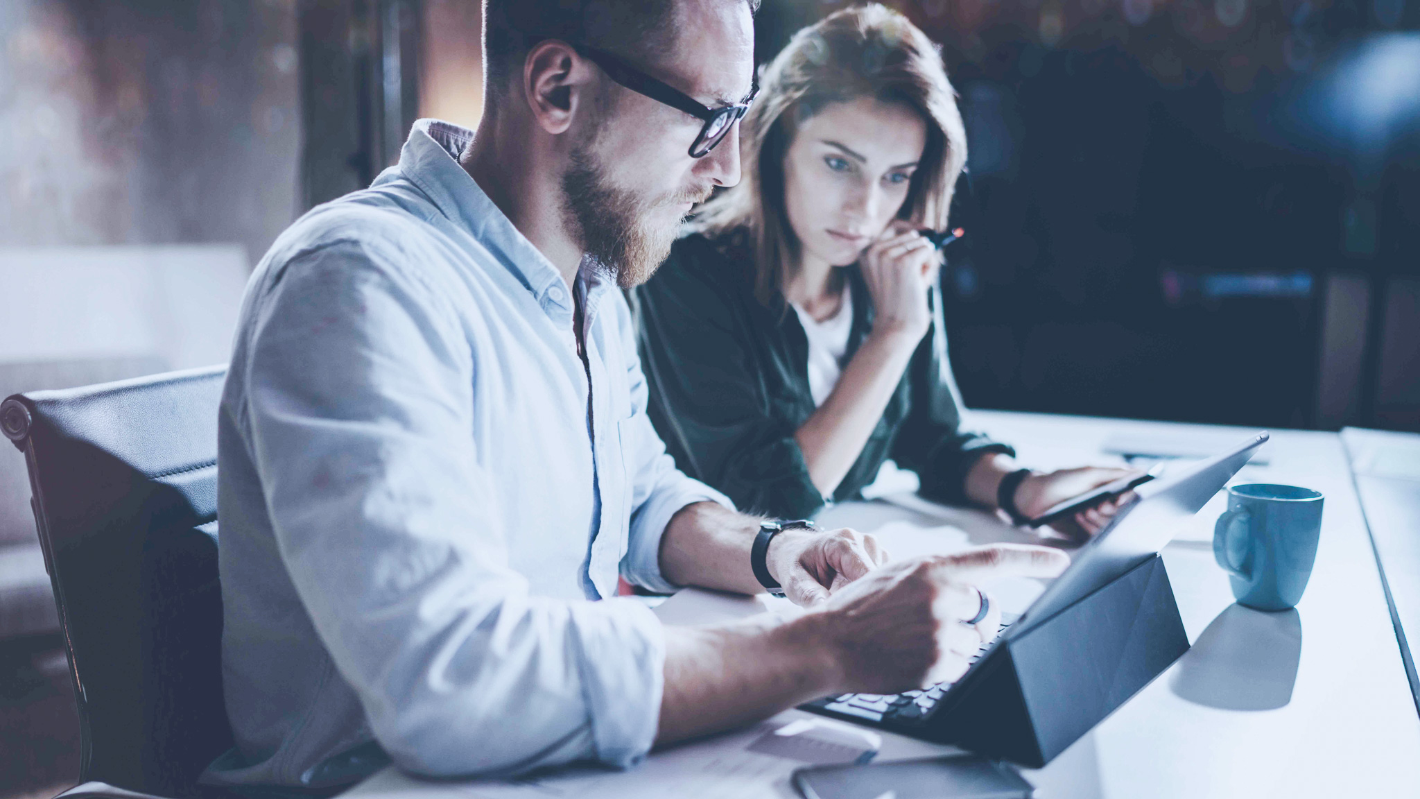Man och kvinna tittar och pekar på en surfplatta